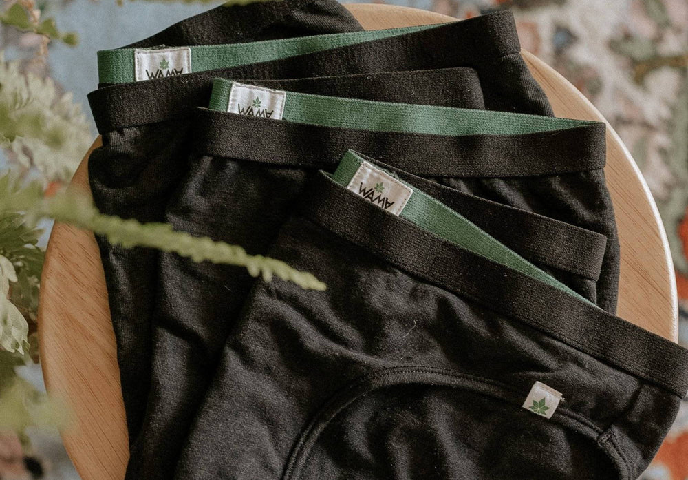 A flat lay of three pairs of WAMA Underwear, made of hemp fabric, sit on a stool.