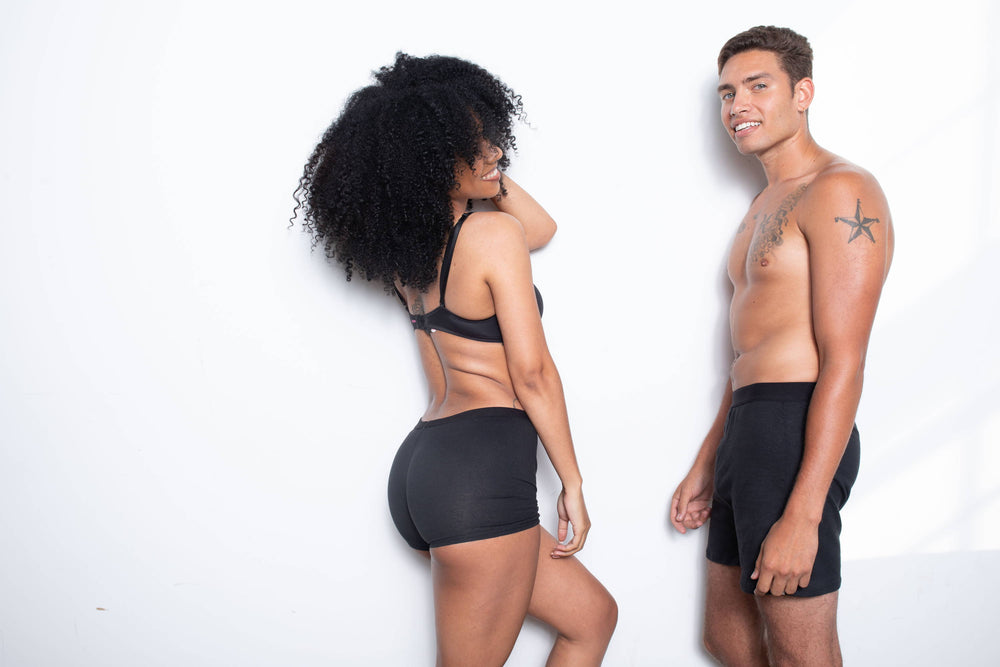 A man and woman stand wearing perfect-fitting WAMA underwear thanks to an underwear size chart.