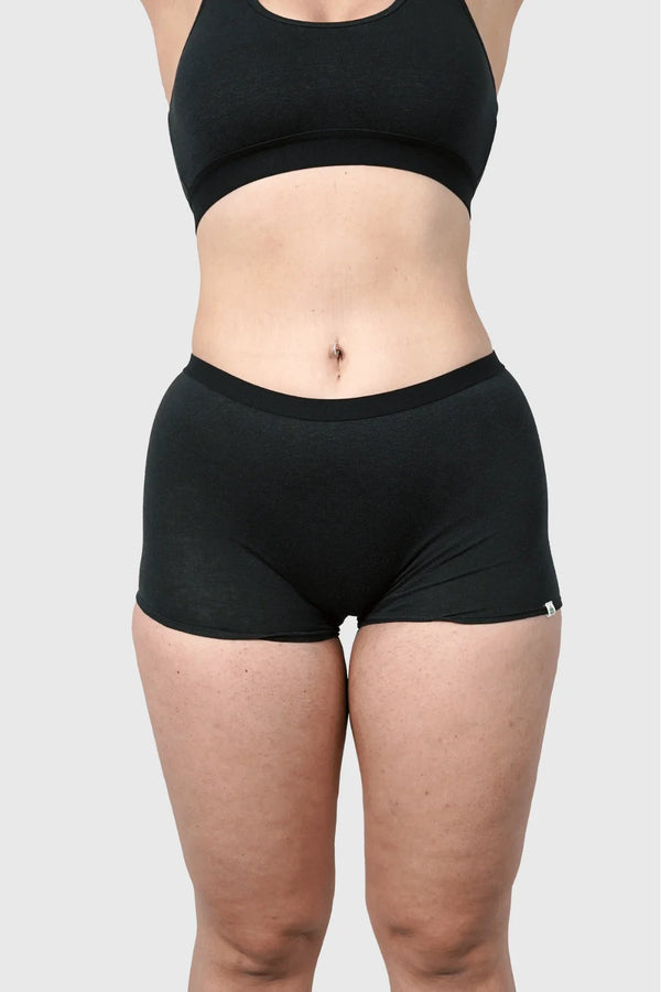 Front view of Hemp Boy Shorts in Black on model wearing size M, 5'10” dress size 6