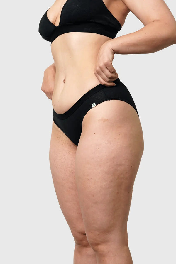 Side view of Hemp Bikini in Black on model wearing size M, 5'10” dress size 6